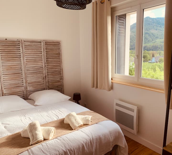 宽敞的卧室，配有衣帽间和书桌。山景。