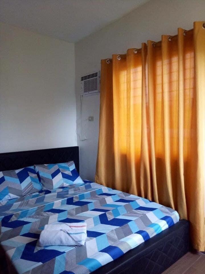 Gastenslaapkamer met queensize bed en airconditioning. 