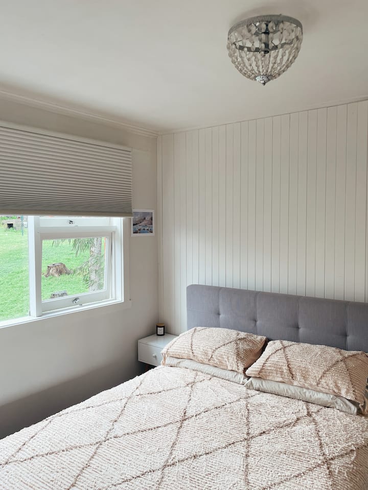 Hermosas vistas a la naturaleza desde la ventana del dormitorio. Persianas de bloqueo de panal Luxaflex en la ventana de la habitación.