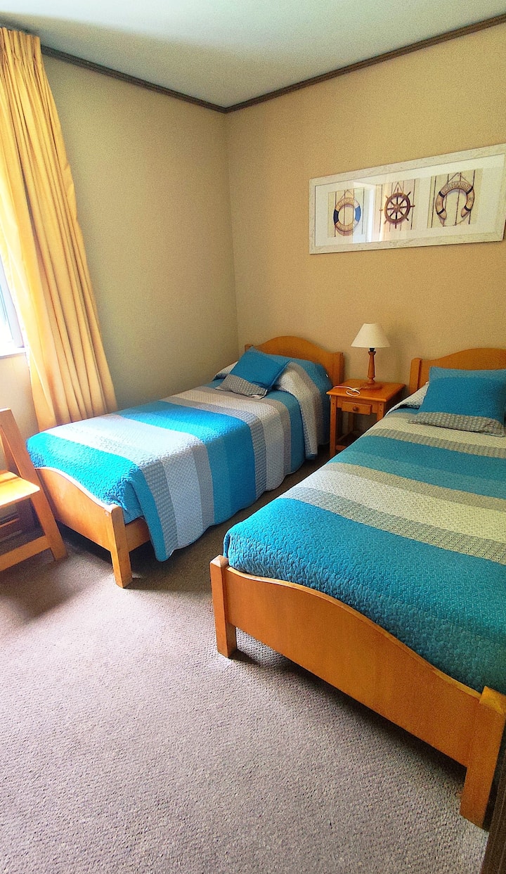 Соба со 2 единечни кревета, прозорец со поглед кон шумата. Голем плакар со полици и куки за чување облека.