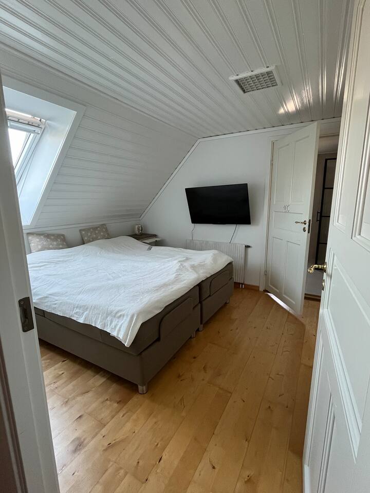 מיטה זוגית. מיטות חשמליות מתכווננות. דלת לחדר הרחצה. 