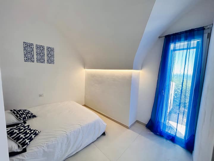 غرفة نوم ثانية بسرير مزدوج وإمكانية الوصول المباشر إلى الخارج من خلال باب نافذتها المستقلة 