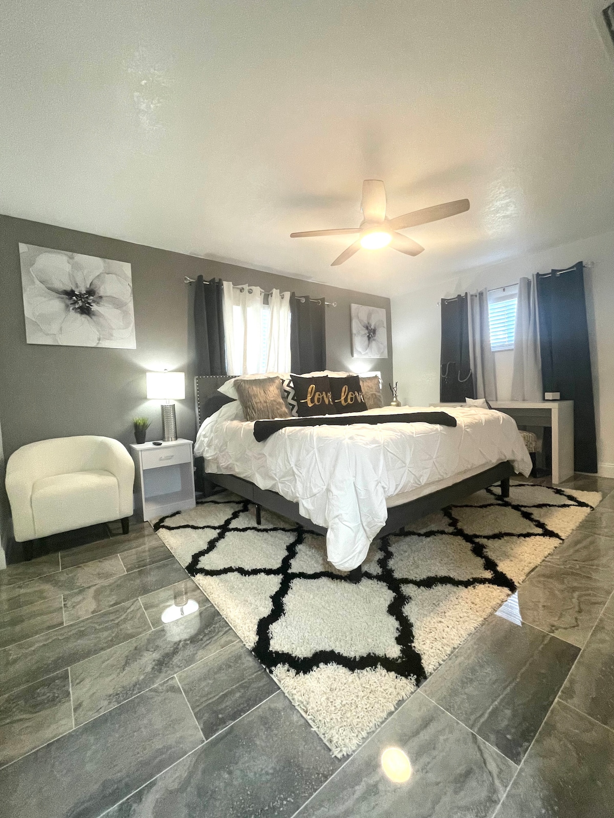 Cama tamaño king con escritorio de oficina, televisor inteligente, vestidor. Este es un dormitorio grande.