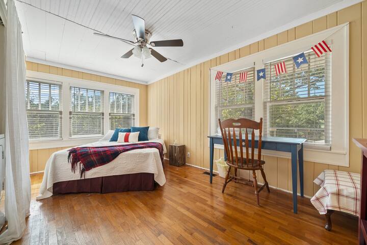 A queen size bed with a workspace