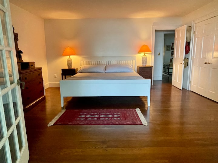 Veľká hlavná spálňa s manželskou posteľou King a výhľadom na rieku cez francúzske dvere a okná. 