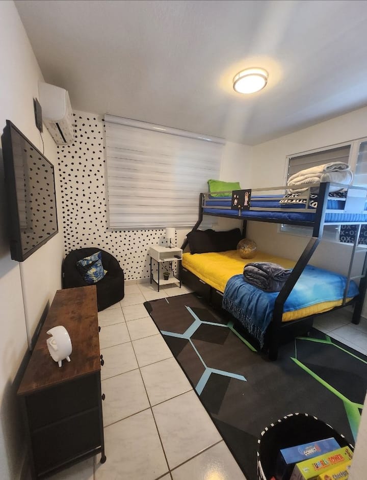 Detta är det roliga rummet. Våningssängen är en full storlek med en tvilling på övervåningen,  för 3 personer. Barn, inte så mycket barn... eller vuxna kan stanna. Det har en 40" TV, en luftkonditioneringsenhet och ett nattduksbord som är en laddstation. Det är här spelen finns. 
