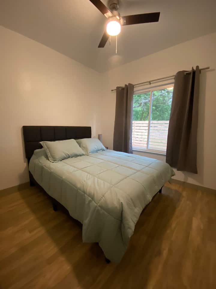 Bekväm Queen size-säng i sovrummet med mörkläggningsgardiner och privat garderob.