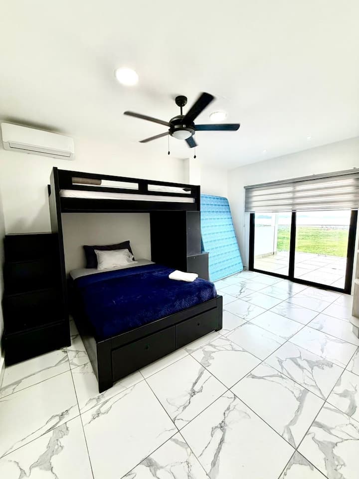 房间位于顶楼，配有一张双层床，底部配有一张双人床，顶部配有一张单人床，外加一张双人床垫。配备全功能卫生间和阳台。