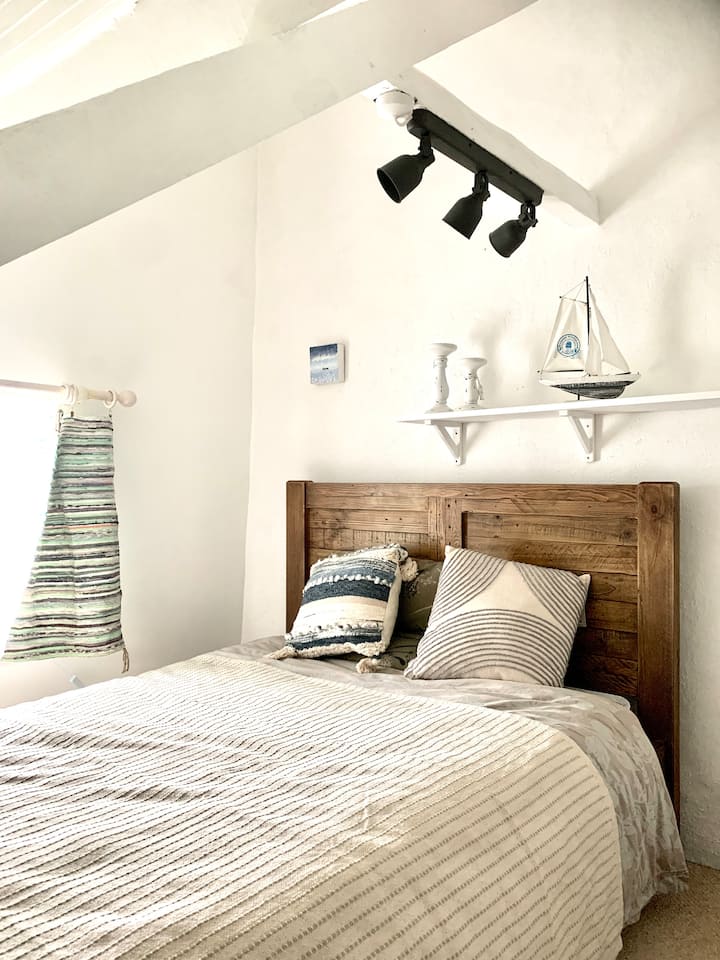 ห้องนอน 2 เป็นห้องนอนคู่ในรังอีกา! ด้วยเพดานที่ลาดเอียงและแผงไม้ให้ความรู้สึกชายฝั่งเบาๆที่น่ารักและเป็นสวรรค์ที่เงียบสงบที่ด้านบนของบ้าน 