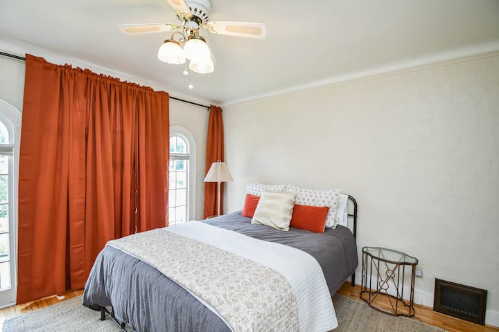 Dormitorio principal con una cama tamaño queen hecha para ti con un edredón para abrazos acogedores y una colcha más ligera para un clima más cálido. 