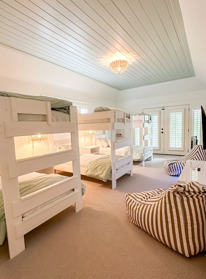 Room 1 - the bunkroom offers 3 sets of bunkbeds, new 50" Roku Smart TV, LED console, private ensuite bathroom, oversized closet, new carpet, new paint, and direct access to the pool / backyard.