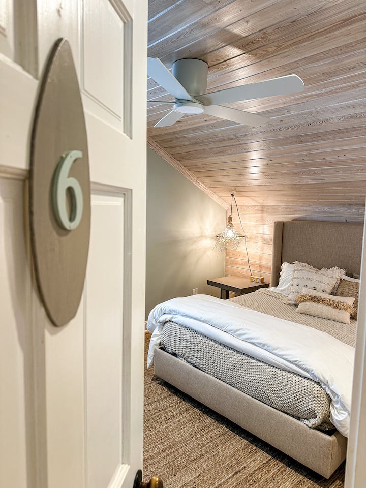 Room 6 - complete with new queen memory foam cooling mattress, new 40” Roku smart TV, custom lighting sourced from Bali, ceiling fan, alarm clock with wireless phone charging, shared bathroom, plantation shutters, new paint, and more.  