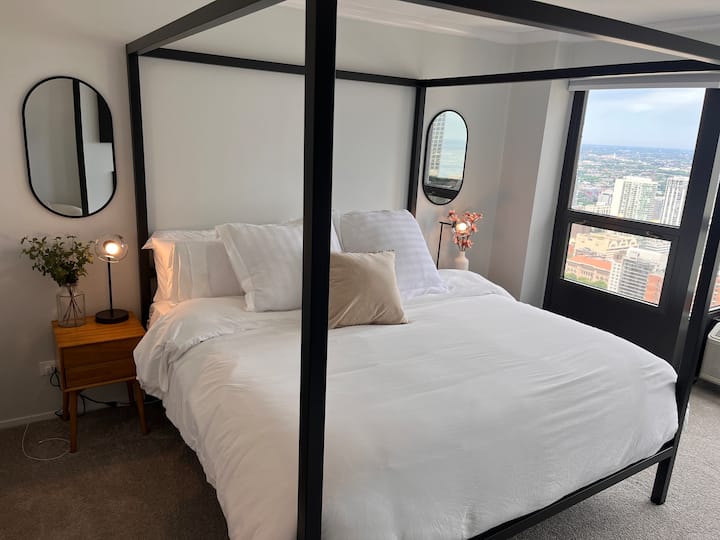 La chambre principale dispose d'un lit king size, de deux tables de chevet, d'un placard, d'une commode, d'une cheminée et d'une télévision connectée. L'espace de travail bien équipé offre une vue magnifique et dispose d'un bureau, d'une chaise, d'un moniteur, d'une souris, d'un clavier et d'une station d'accueil.