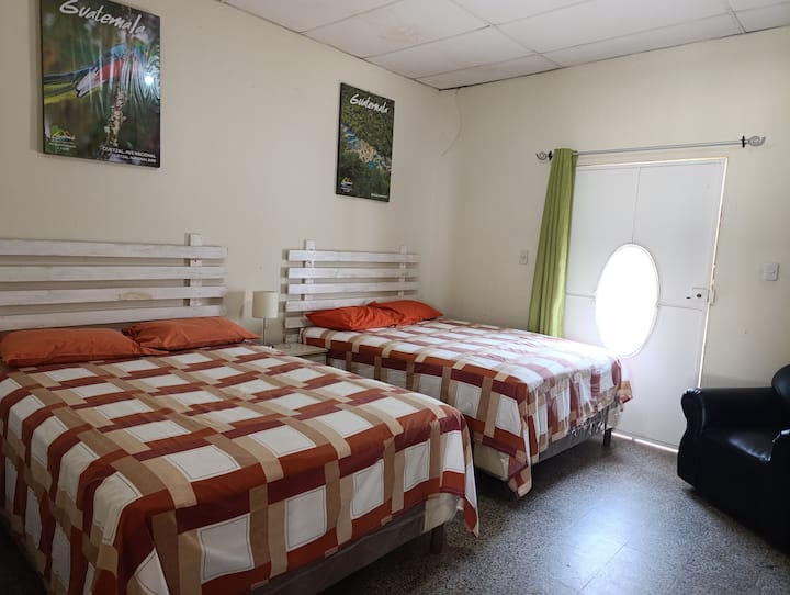 habitación con dos camas matrimoniales , un sofá , planchador 