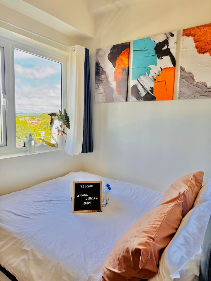 Bedroom with a relaxing view, full-size bed with pull-out, aircon, massage chair, wardrobe, double mirrors, vanity mirror, and a working table—designed for comfort, style, and a restful stay.