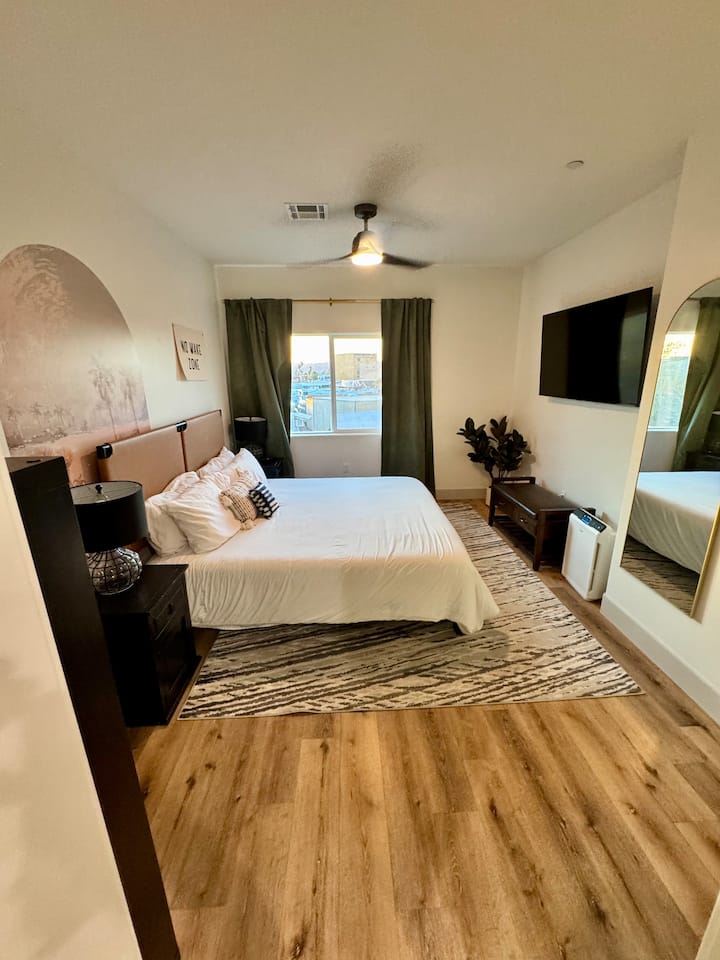 Primárna spálňa s 58-palcovou televíziou, manželskou posteľou a prístrojom na biely šum. 