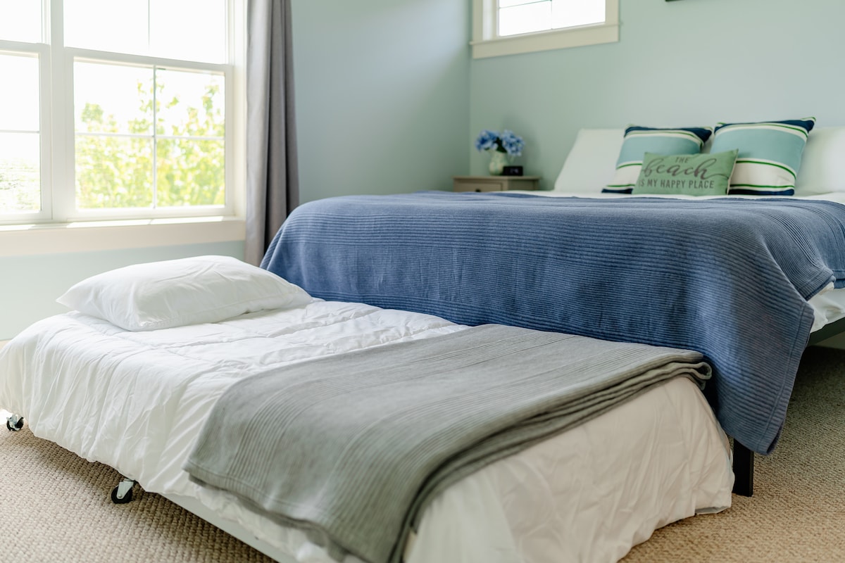 Manželská posteľ s oddelenými posteľami a pripojenou kúpeľňou.