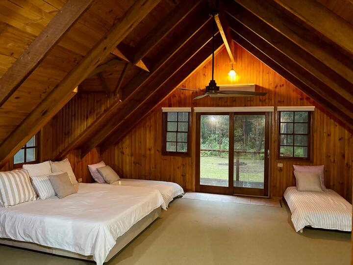 Loft à l'étage chambre 1, lit King Size et 2 lits simples. Espace suspendu pour vêtements. Balcon donnant sur la cour. 