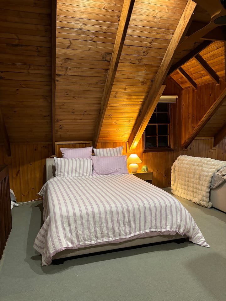 Loft à l'étage chambre 2, 1 lit Queen Size et 2 lits simples. Cet espace partage également de l'espace avec un grand salon confortable et un espace de télévision. 