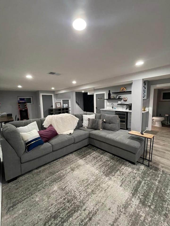 חלל מגורים נמוך יותר עם טלוויזיה חכמה 75אינץ ', בר רטוב ומיני ארקייד