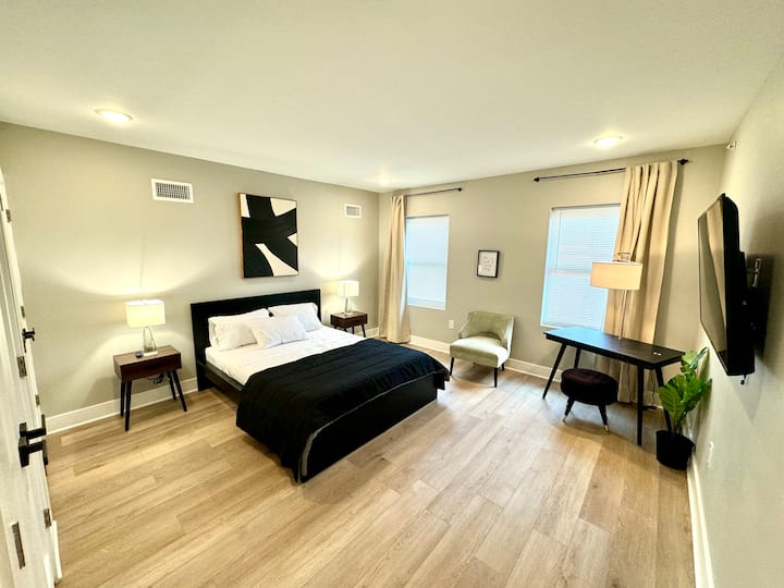 ห้องนอนใหญ่ที่ตกแต่งอย่างหรูหรามีเตียงควีนไซส์ โต๊ะทำงาน โซฟาอ่านหนังสือ ทีวี ตู้เสื้อผ้ากว้างขวาง และห้องน้ำส่วนตัวเพื่อความสะดวกสบายของคุณ