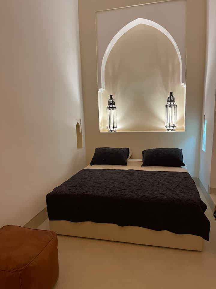 Спалня с двойно легло с голяма душ кабина и деликатни цветове, благоприятни за релаксация. Тоалетната е затворена. Голям прозорец, прозорец в банята и прозорец на спалнята