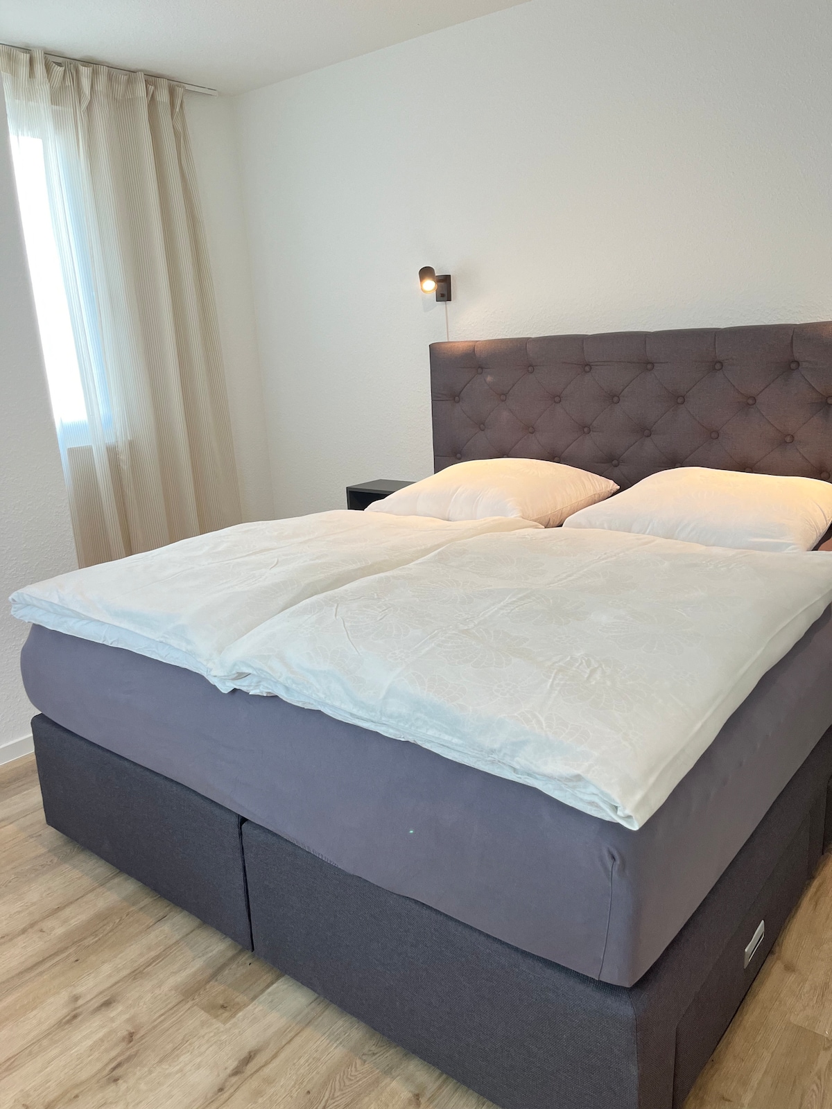 Nuestra lujosa cama de somier con mesitas de noche e iluminación de lectura. Las persianas exteriores eléctricas hacen que el dormitorio sea agradable y oscuro.