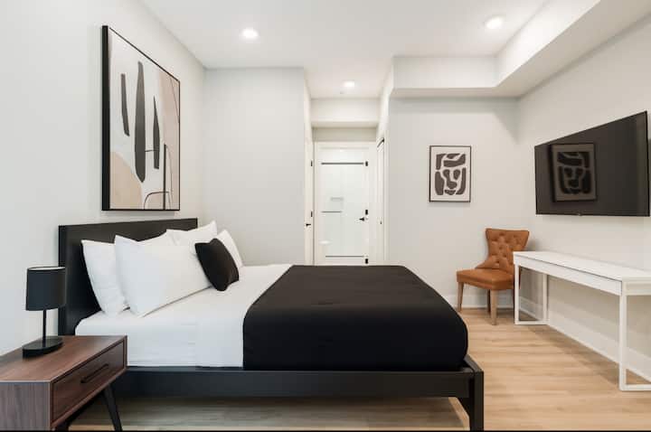 מיטת קווין סייז, טלוויזיה עם מסך שטוח, שולחן עבודה וארון גדול, מעוצב להפליא עם חדר רחצה צמוד.