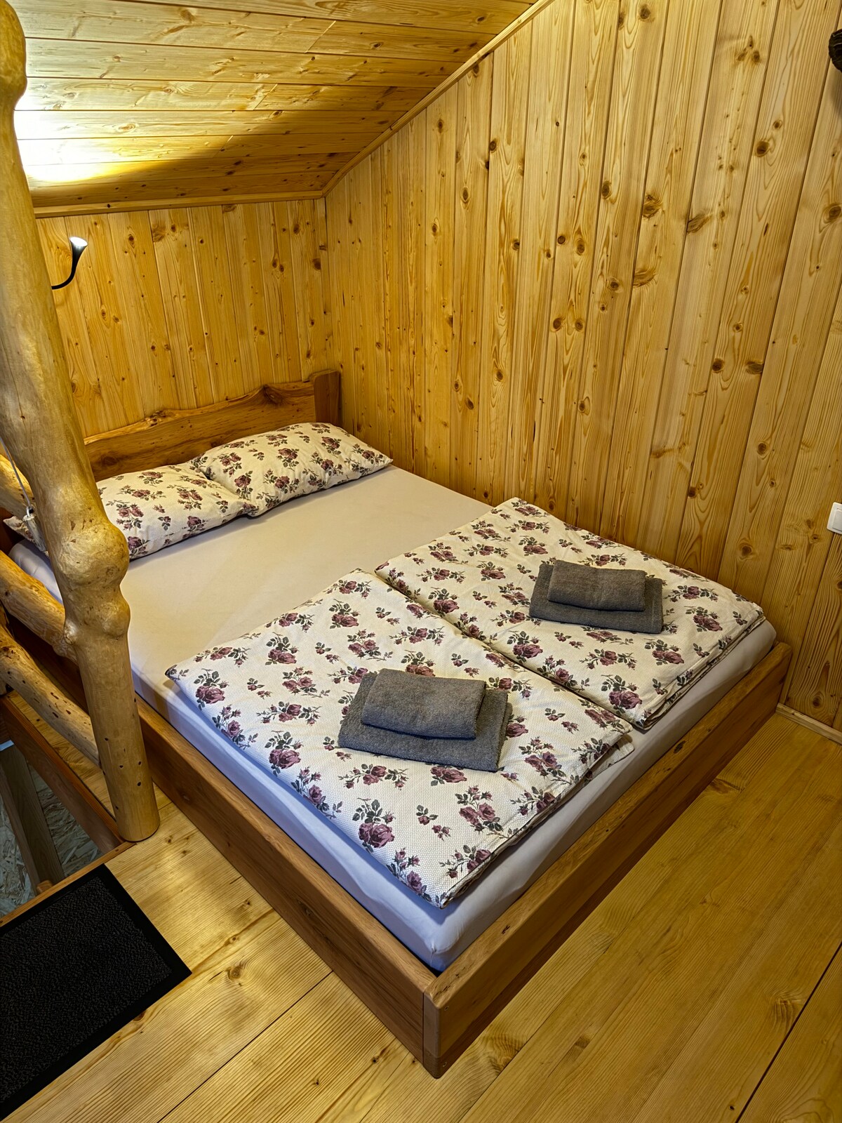 חדר השינה מוקף בעץ מקומי. המיטה עשויה מעץ אלון עם מזרן נוח.