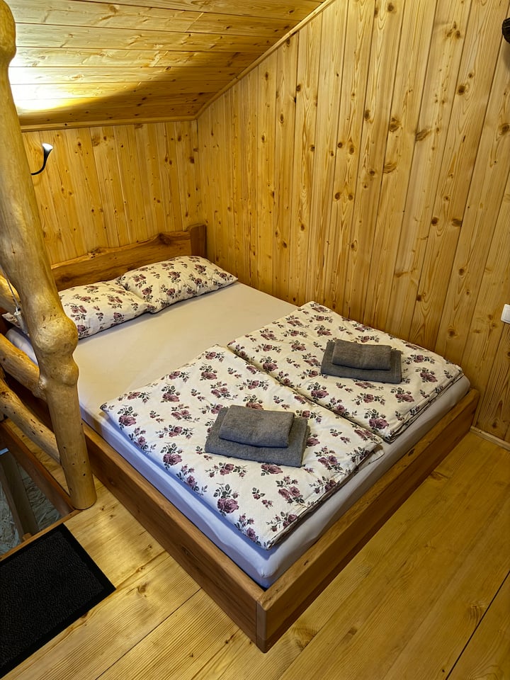 Საძინებელი გარშემორტყმულია ადგილობრივი ხით. Მუხისგან დამზადებული საწოლი კომფორტული მატრასით.