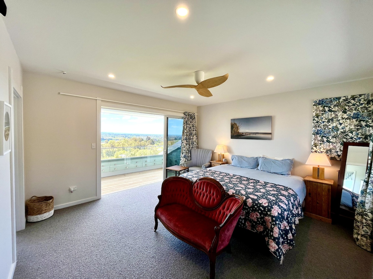 Dormitorio principal con cama «super king», silla y mesa para leer y disfrutar de un rato de tranquilidad mientras contemplas Hawke's Bay.
NOTA: Este dormitorio principal está en un tramo de escaleras en el segundo piso.