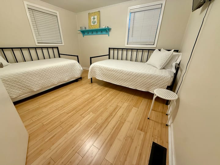 Tres camas individuales. Una es una cama nido. También hay un televisor y un armario aquí. 