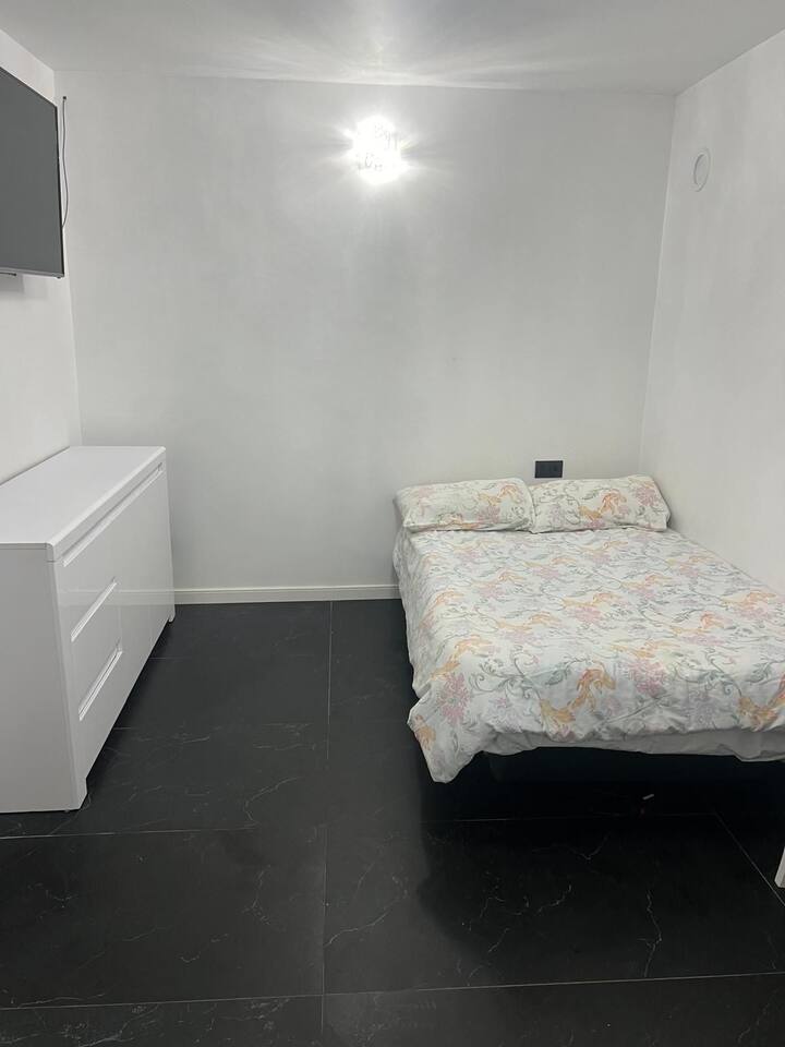 Esta habitación está en el centro de la casa, entre la cocina y el pasillo/baño, desde ella se accede al exterior en la terraza. Tiene una cama extraíble de 1,5 m x 1,9 m que puede ser ajustada si quieres más espacio o pasar tiempo viendo la televisión.