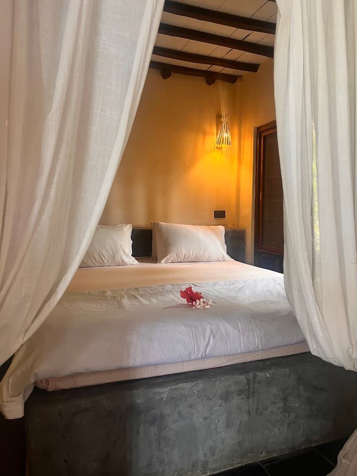 Წარმოიდგინეთ, რომ იძირებით ბალის სტილის საწოლში. Ლავანდის მკრთალი სურნელი და ფოთლების ჩურჩული გარეთ ქმნის დამამშვიდებელ ლულაბას, რომელიც მშვიდად დაგამახსოვრებთ თავს. Ეს მყუდრო თავშესაფარი შექმნილია მხოლოდ დასვენებისთვის, სადაც საზრუნავი იშლება და ოცნებები გელით.