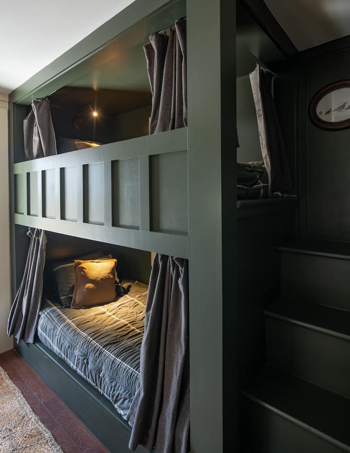 The built-in bunks in the downstairs hallway include reading lights, zip bedding for easy tidying, and curtains for privacy! 