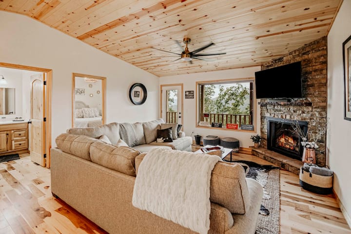 Perfect for couples, this cozy mountain cabin offers a romantic retreat. Enjoy the warmth of a stone fireplace, plush seating, & stunning mountain views through large windows. Unwind in the peaceful surroundings & reconnect in comfort and tranquility
