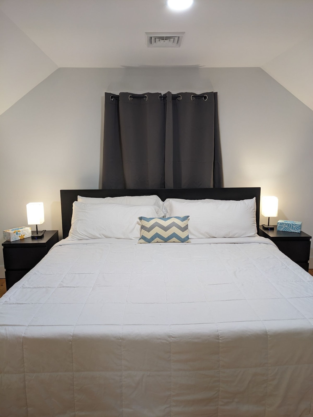 לישון בנוחות במזרן הקצף שלנו עם שני סטים שונים של כריות. לכל צד של המיטה יש מנורות ליד המיטה עם מטעני USB ושקעי חשמל.