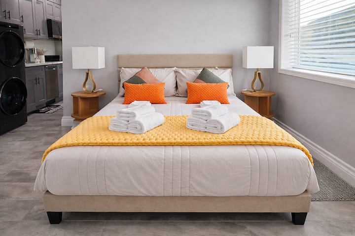 Primary sleeping area with a comfortable queen bed, bedside tables, soft lighting, and mini-split AC—ideal for professionals seeking a quiet, well-appointed space for longer stays.