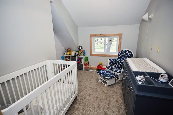 Guardería con cuna, cambiador y silla mecedora. Nivel superior