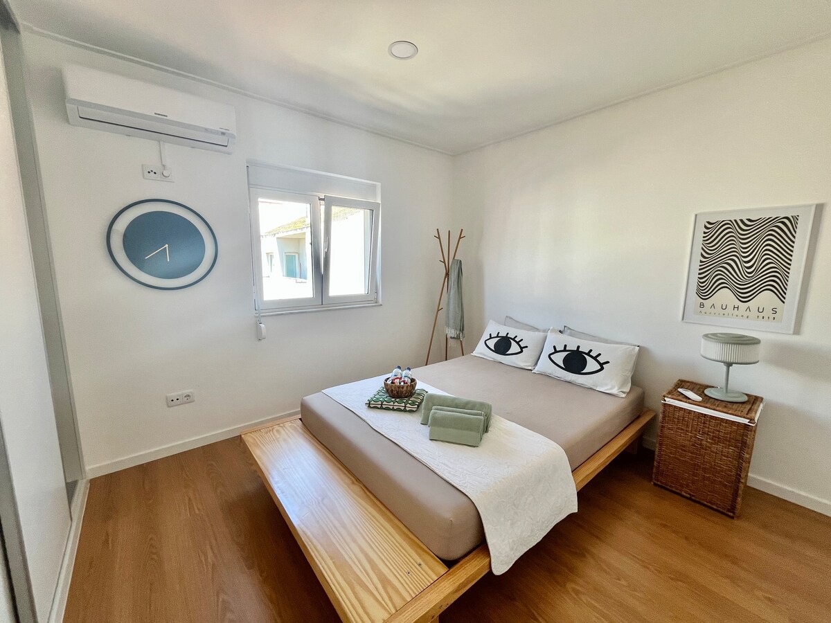 Голяма спалня с климатик, гардероб, странична масичка, хавлиени кърпи за баня и допълнително спално бельо