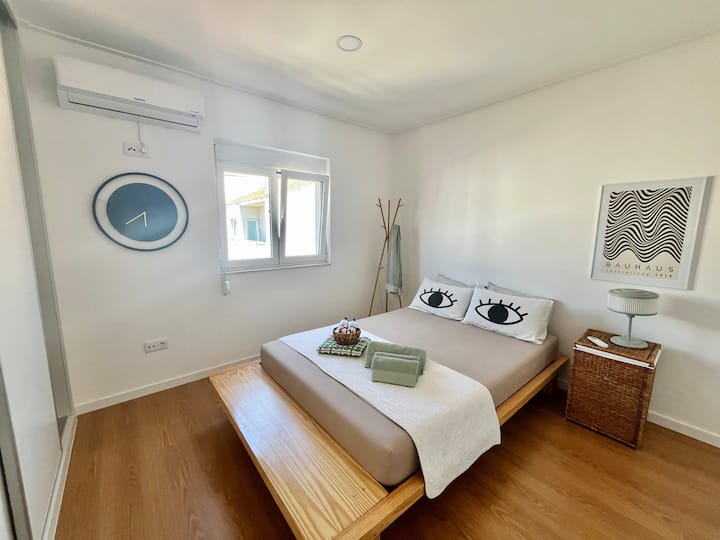 Grande chambre avec climatisation, armoire, table d'appoint, serviettes de bain et literie supplémentaire