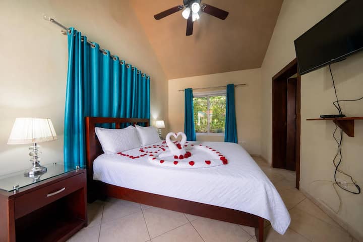 Suíte — cama king, coberta de rosas