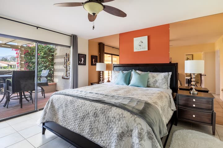 One of two bedroom suites, this room features a king bed, walk-in closet, en-suite bathroom, TV with streaming options, and access to the back patio via a glass slider.