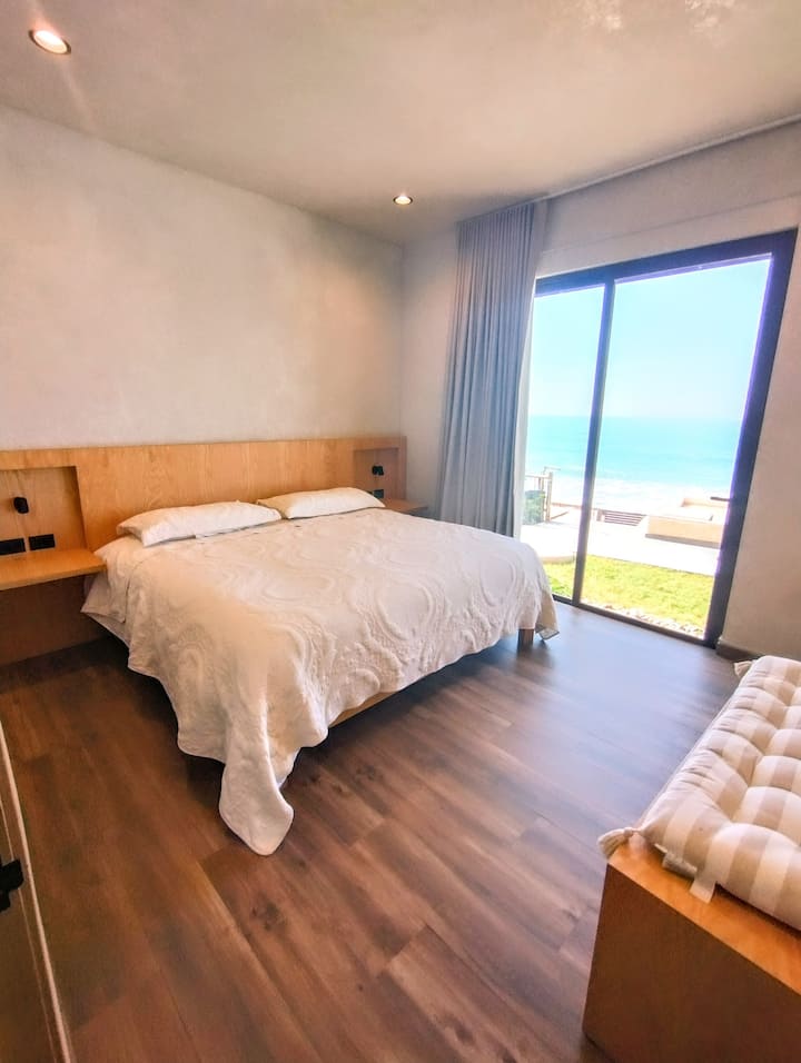 "תיהנו מהנוחות של חדר שינה ראשי מרווח המצויד במיטת קינג - סייז, חדר רחצה ושירותים פרטי, ארון מרווח וחלון שמאפשר כניסה לאור טבעי יפהפה ונופים יוצאי דופן ."
