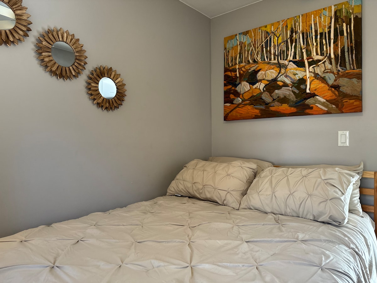 Kjo dhomë gjumi e rehatshme është super e lezetshme dhe e rehatshme. 

Arti mbi krevat është "The Birch Grove" i Tom Thomson, i cili u pikturua në dimër 1915-16 në Algonquin Park.