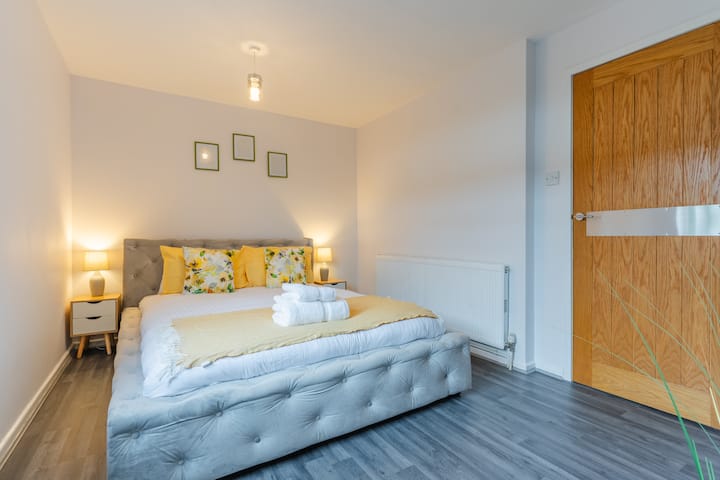 El dormitorio emana una elegancia tranquila con un toque de lujo. Dominando el espacio hay una cama tamaño king, grande y acogedora. A un lado de la habitación, cerca de una gran ventana con vistas a un jardín sereno, se encuentra una mesa de estudio y una silla.