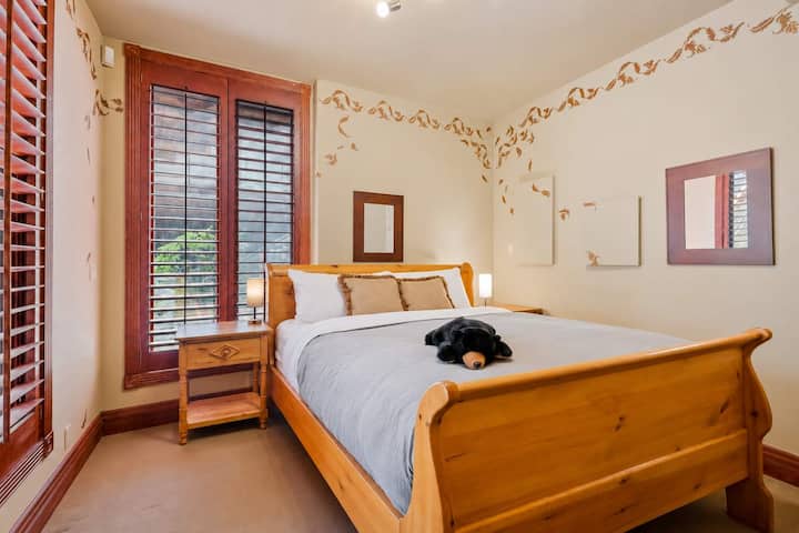 Cette charmante chambre avec lit queen size se trouve à l'étage inférieur, au bout du couloir, ce qui offre une intimité totale et un accès facile au jacuzzi et au foyer de la terrasse inférieure.