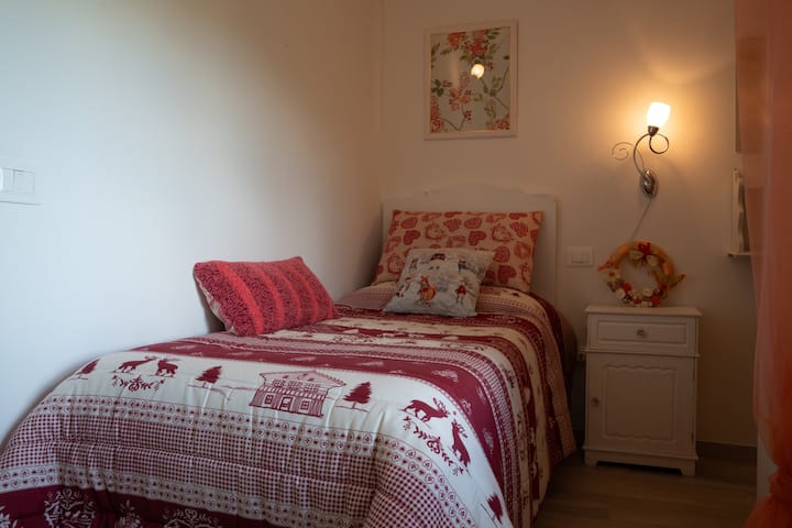 Komorná a farebná jednolôžková izba s novou posteľou z pamäťovej peny, šatníkom s komodou a veľkým panoramatickým oknom.