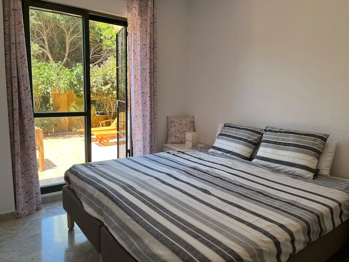 1st modern double room with built-in wardrobes along one wall, large windows with a view of a terrace and the romantic Moorish-style castle.