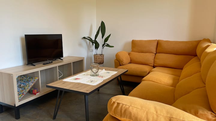 Salón con TV y sofá grande. Planta 0.